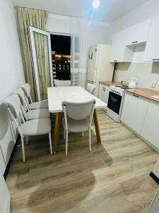una cucina con tavolo e sedie in una cucina di Turkestan Apartment, Жана кала, возле обл акимата a Tridtsatʼ Let Kazakhstana