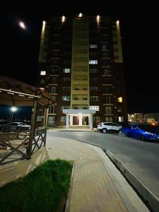 un parcheggio di notte di fronte a un edificio di Turkestan Apartment, Жана кала, возле обл акимата a Tridtsatʼ Let Kazakhstana