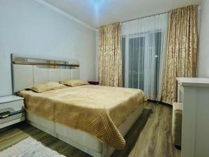 una camera da letto con un letto grande e una finestra di Turkestan Apartment, Жана кала, возле обл акимата a Tridtsatʼ Let Kazakhstana