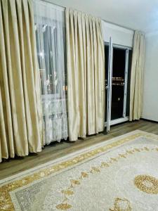 un soggiorno con tende, tappeto e finestra di Turkestan Apartment, Жана кала, возле обл акимата a Tridtsatʼ Let Kazakhstana