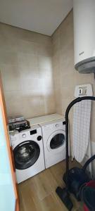 a washer and dryer in a small room at Boa Passagem AL in Bicas +2 photos