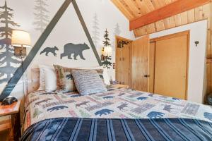 a bedroom with a bed with a bear stenciled on the wall at Big Bear Cabin with Treetop Views 3 Decks Arcade Game, Fireplace, BBQ, WIFI in Big Bear City