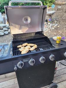 a grill with a bunch of food on it at Big Bear Cabin with Treetop Views 3 Decks Arcade Game, Fireplace, BBQ, WIFI in Big Bear City