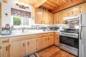 a kitchen with wooden cabinets and a stove at Big Bear Cabin with Treetop Views 3 Decks Arcade Game, Fireplace, BBQ, WIFI in Big Bear City +23 photos