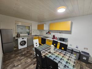 a kitchen with yellow cabinets and a table with chairs at Ferienhaus Adler in Unterlüß
