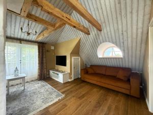 a living room with a couch and a tv at Kooli 7 - II floor sea view apartment with balcony in Haapsalu Old Town in Haapsalu