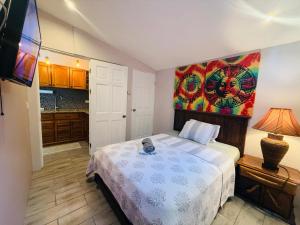 a bedroom with a bed and a painting on the wall at Paradise stay beach walk and dinning in Jacó +23 photos