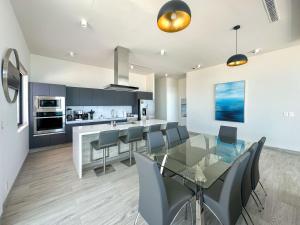 a kitchen and dining room with a glass table and chairs at Waves & Views Luxury 3BR Oceanfront Condo in Puerto Peñasco +131 photos