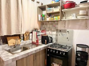 a small kitchen with a stove and a sink at Nyumbani Studio in Ukunda Airport