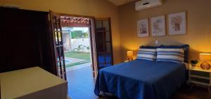 a bedroom with a bed and a door to a yard at Piscina Aquecida Casa no Thermas de Sta Bárbara in Santa Bárbara do Rio Pardo +18 photos