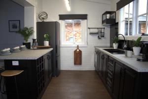eine Küche mit schwarzen Schränken und einer Arbeitsplatte in der Unterkunft Elsie Cottage in Devonport + 5 Fotos