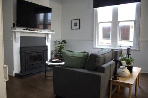 ein Wohnzimmer mit Couch und Kamin in der Unterkunft Elsie Cottage in Devonport