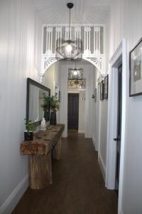 einen Flur mit einem Tisch und einem Spiegel an der Wand in der Unterkunft Elsie Cottage in Devonport