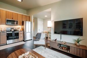 a kitchen with a large flat screen tv on the wall at Prime Eagle River Stay - Walkable Location in Eagle River