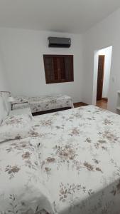 a bedroom with a large bed with a floral bedspread at Pousada Alejandro in Cunha +79 photos