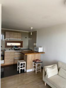 ein Wohnzimmer mit Couch und Küche in der Unterkunft Your refuge in El Yeco- Algarrobo in Algarrobo