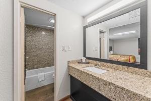 a bathroom with a sink and a mirror at Guest Inn Rogers in Rogers