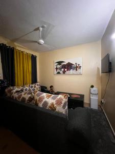 a living room with a couch and a tv at F&M comfy homes in Mombasa