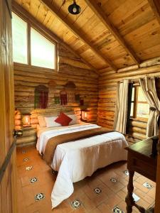 a bedroom with two beds in a log cabin at Cabaña Flor de Agave in Tres Marías