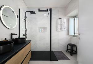 a bathroom with a sink and a shower with a mirror at Beira Da Rocha in Ponta Delgada +39 photos