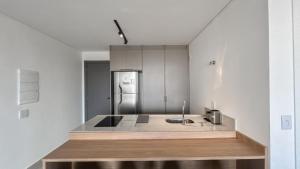 a kitchen with a sink and a refrigerator at Estúdio Aconchego Central in Campo Grande