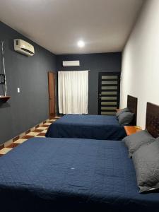 two beds in a bedroom with blue walls at Casa Camino Real, Habitación 1, Baño privado, Cafetera Escritorio in Ciudad Valles +12 photos