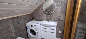 a bathroom with a washing machine and a sink at Home comfort in Verkhovyna