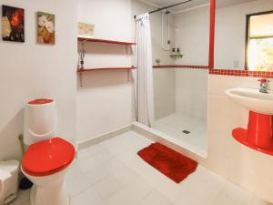 a bathroom with a red toilet and a sink at Casa Laureles in Filandia +49 photos