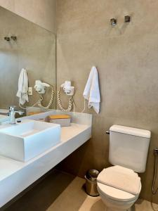 a bathroom with a sink and a toilet and a mirror at Ilhabela Flat in Ilhabela +4 photos