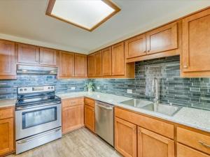 kuchnia z drewnianymi szafkami i urządzeniami ze stali nierdzewnej w obiekcie 1-Bedroom plus Loft at The Pines with Forest Views, No Cleaning Fees, Kids Ski Free condo w mieście Keystone