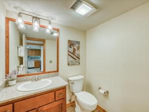 łazienka z toaletą, umywalką i lustrem w obiekcie 1-Bedroom plus Loft at The Pines with Forest Views, No Cleaning Fees, Kids Ski Free condo w mieście Keystone +15 zdjęć