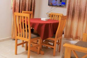 ein Esstisch mit einer roten Tischdecke in der Unterkunft Arien Hotel in Hoima