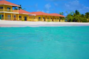 a house on the beach with the water in front at Rendezvous Bay Hotel in Lower South Hill