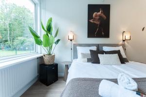 a bedroom with a bed and a large window at Affordable Private Room Near University Tilburg in Tilburg