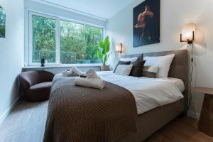 ein Schlafzimmer mit großem Bett und Fenster in der Unterkunft Affordable Private Room Near University Tilburg in Tilburg
