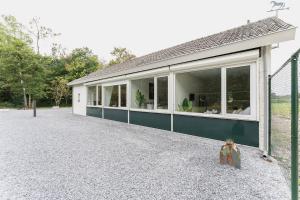 a house with large windows on the side of it at Affordable Private Room Near University Tilburg in Tilburg