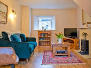 Una sala de estar con un sofá azul y un televisor. en 1 Bed in Hartington 90126, en Hartington