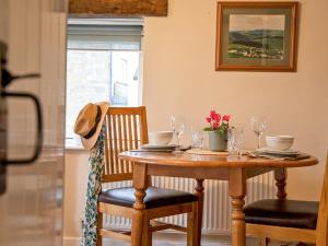 una mesa de comedor con vasos y flores. en 1 Bed in Hartington 90126, en Hartington 5 fotos más
