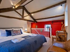 a bedroom with a bed with a blue comforter and a chair at 1 Bed in Hartington 90124 in Hartington
