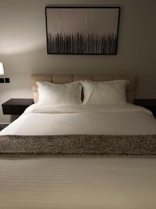 a bed with white sheets and pillows in a bedroom at A studio in Al-Murouj self check in in Riyadh +9 photos