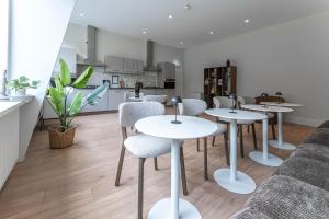 ein Wohnzimmer mit Tischen und Stühlen sowie eine Küche in der Unterkunft Affordable Private Room Near University Tilburg in Tilburg