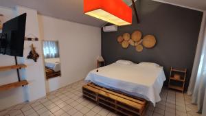 a bedroom with a bed and a flat screen tv at Chalé Hilda in Holambra