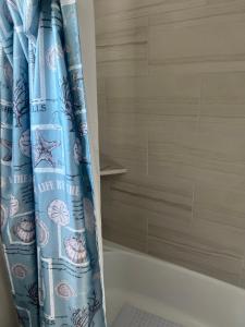 a blue shower curtain in a bathroom next to a tub at Nanashortlet in Rosenberg +14 photos