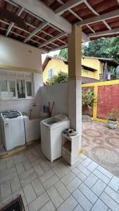 an outdoor patio with a washer and dryer in a house at Casa Completa/Condo Sensacional in Mangaratiba