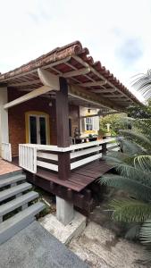 a house with a wooden deck in front of it at Casa Completa/Condo Sensacional in Mangaratiba +41 photos