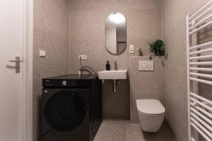 a bathroom with a washing machine and a sink at Nature Budget Bedroom Near University Tilburg in Tilburg