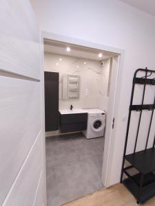 a bathroom with a sink and a washing machine at Podłęże Trawniki Industrial Zone 