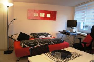 a living room with a red couch and a table at Studio-Appartment Horgen in Horgen