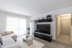 una sala de estar con un sofá y un televisor en Ancora Planetcostadorada, en Salou