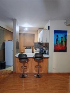 a kitchen with two stools at a kitchen counter at Peaceful stay in Richards Bay